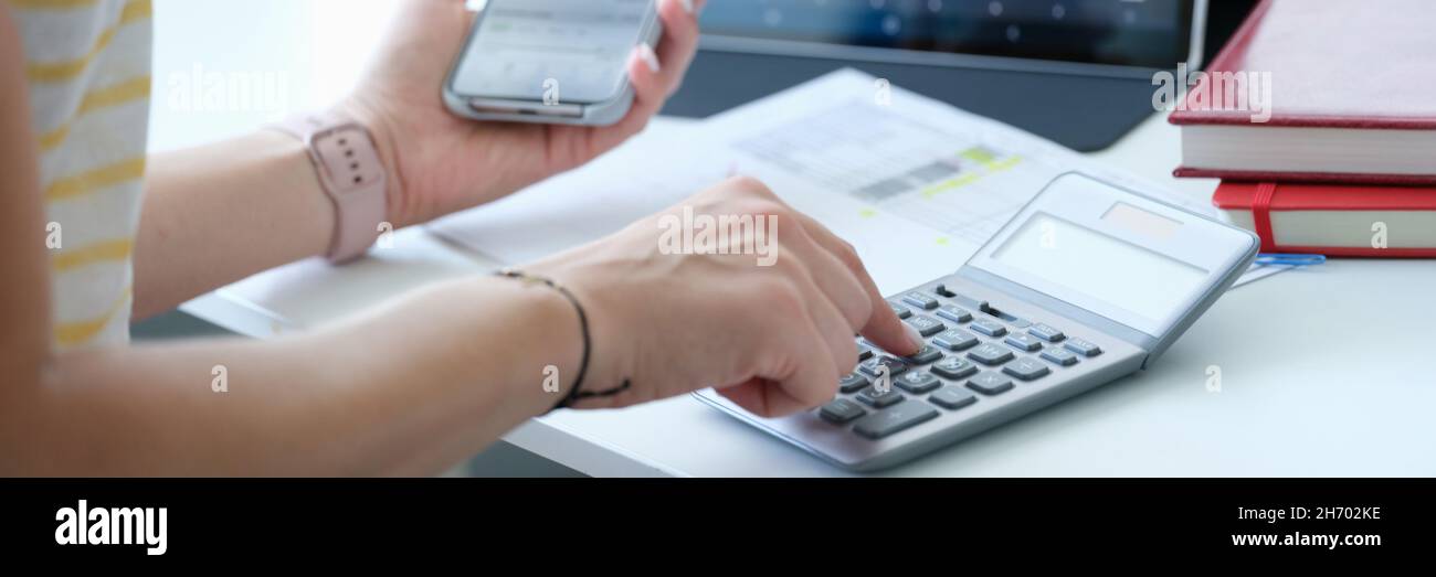 Businesswoman con calculadora de smartphone y portátil calcula los cambios de cambio de la bolsa de valores Foto de stock