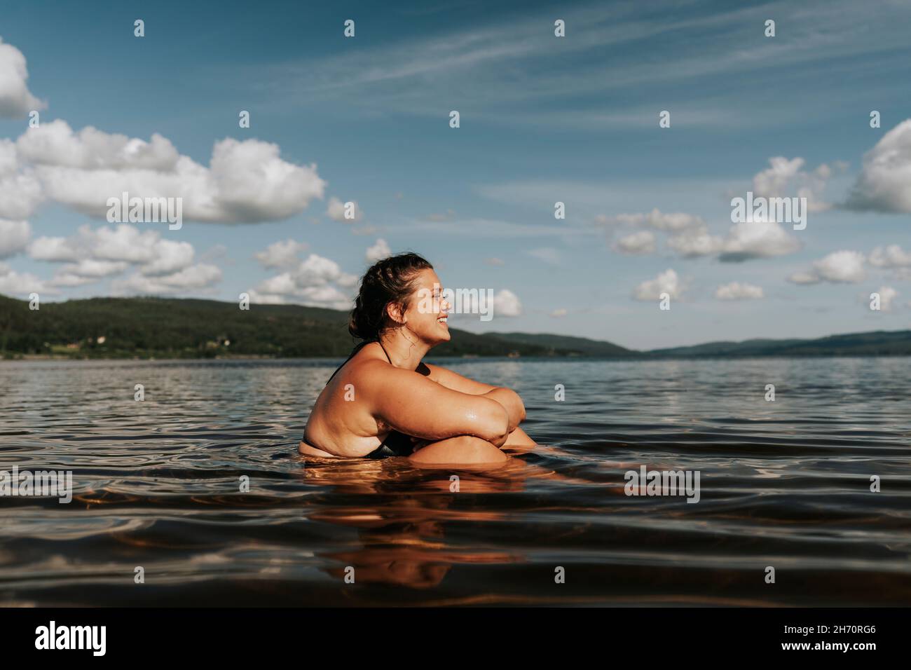 Mujer sentada en el lago Foto de stock