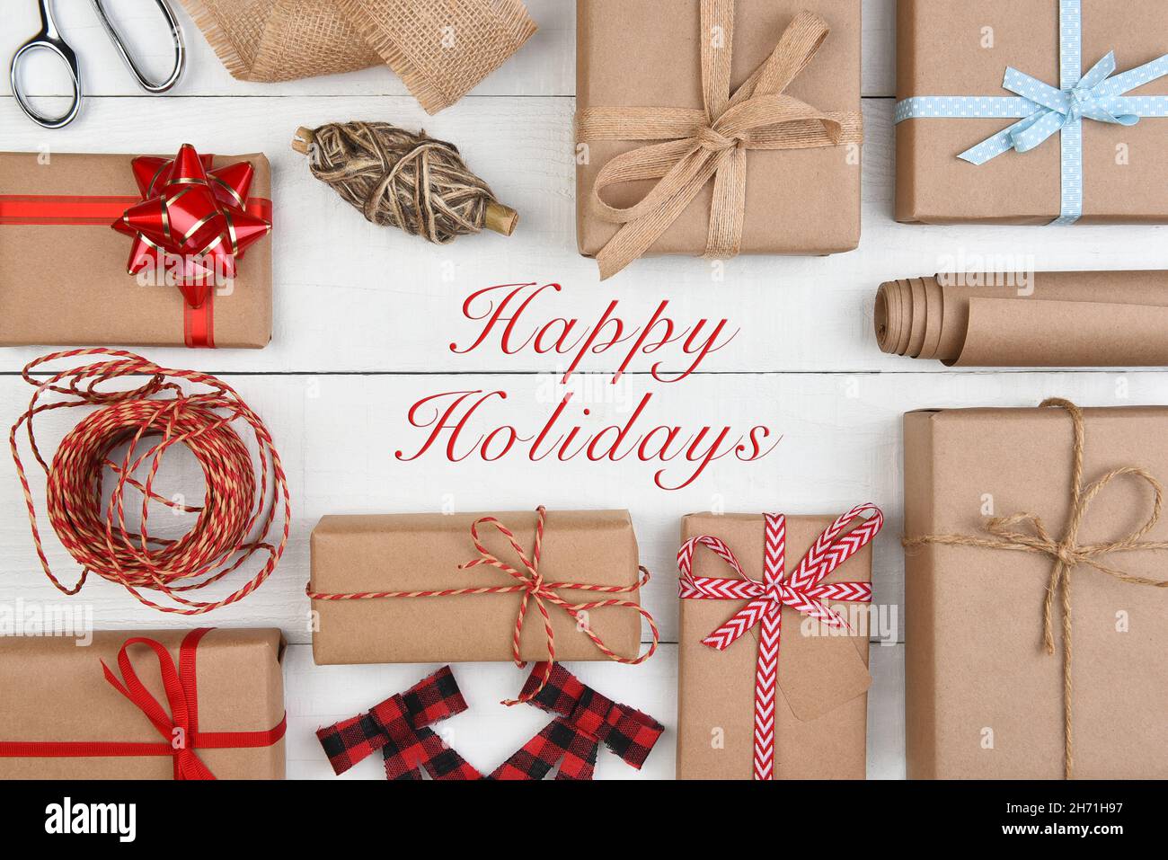 Navidad Plana Lay - Plain brown papel Kraft envuelto regalos y accesorios con feliz día de fiesta en el medio. Foto de stock