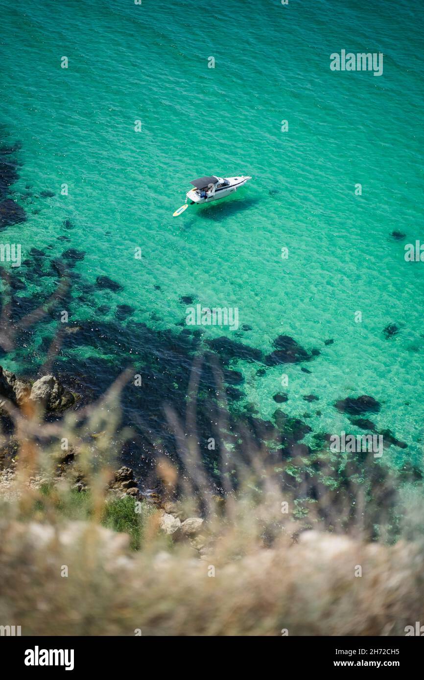 Barco solitario amarrado en la laguna Bounty, Cabo Fiolent en Balaklava, Sevastopol, Rusia. Vista desde la cima de la roca. Azure esmeralda agua de mar de gree Foto de stock