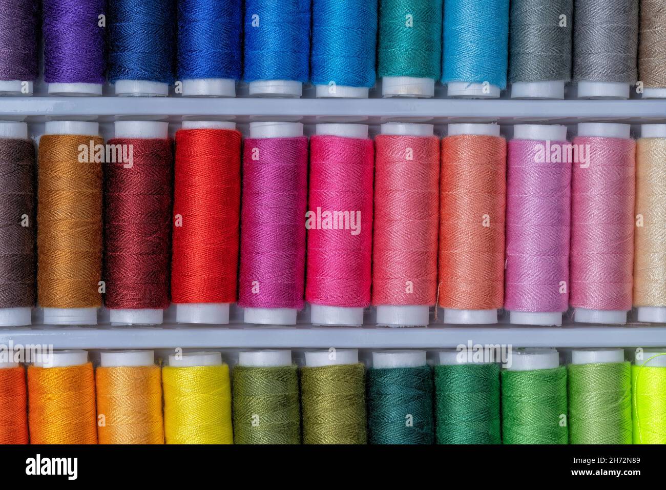 Una colección de bobinas de hilo de coser con hilos de todos los colores  Fotografía de stock - Alamy