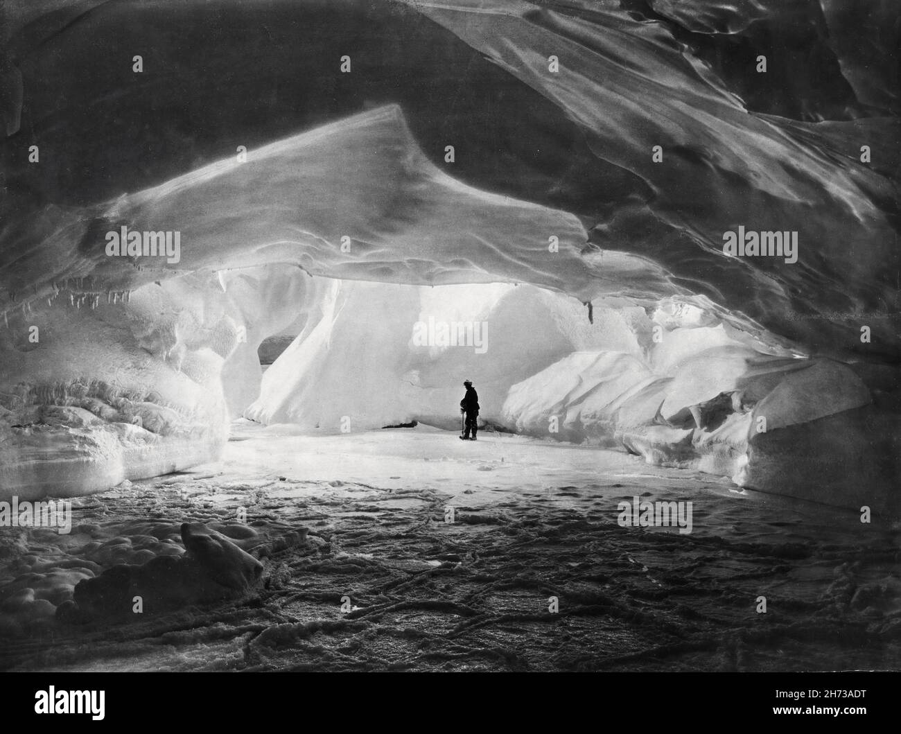 Miembro de la expedición Endurance explorando una cueva de hielo Foto de stock