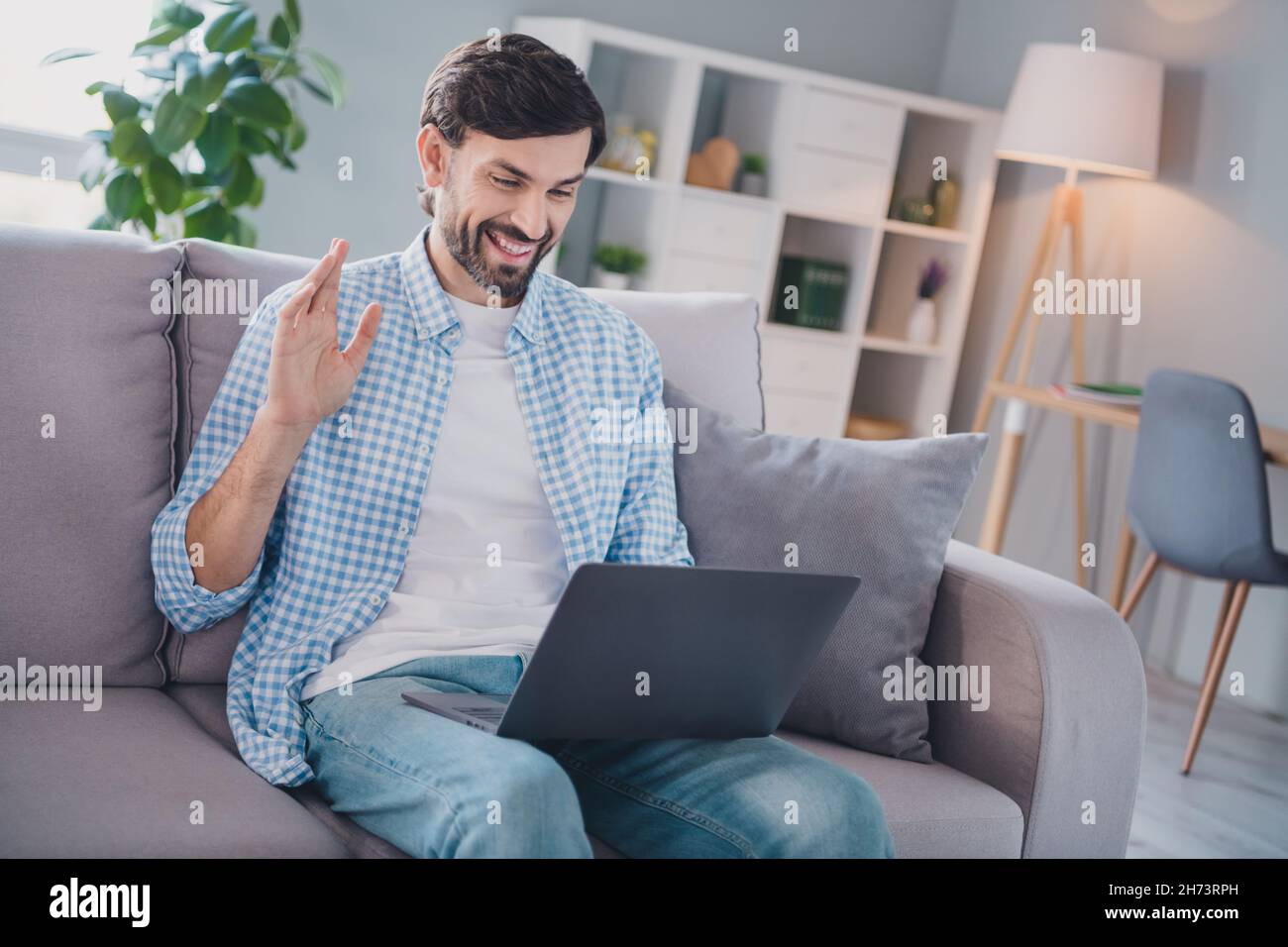 Foto de simpático hombre alegre sentarse sofá remoto conferencia  comunicación llevar ropa informal en casa cómoda en el interior Fotografía  de stock - Alamy