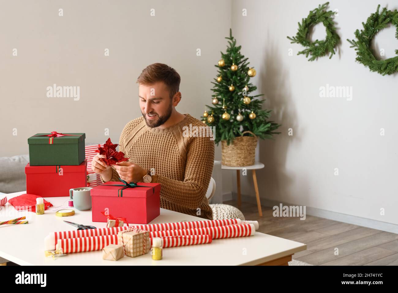 Encontró el regalo perfecto. Un hombre joven guapo que se prepara para la  Navidad Fotografía de stock - Alamy