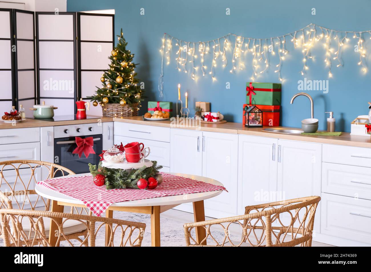 Mesa de comedor con sillas de mimbre en la cocina decorada para Navidad  Fotografía de stock - Alamy