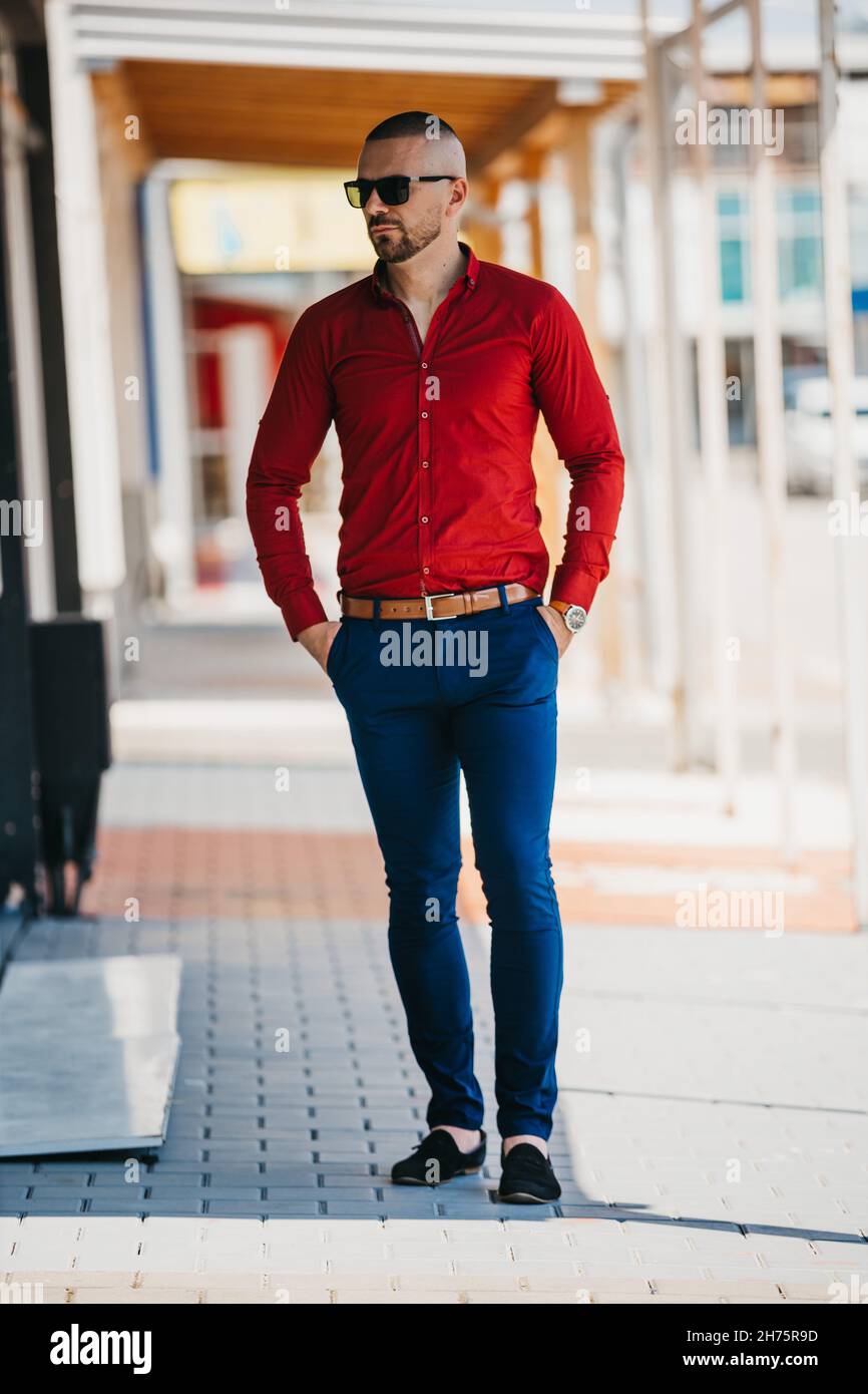 Foto vertical de un joven en una camisa roja con un look de negocios con  gafas de sol Fotografía de stock - Alamy
