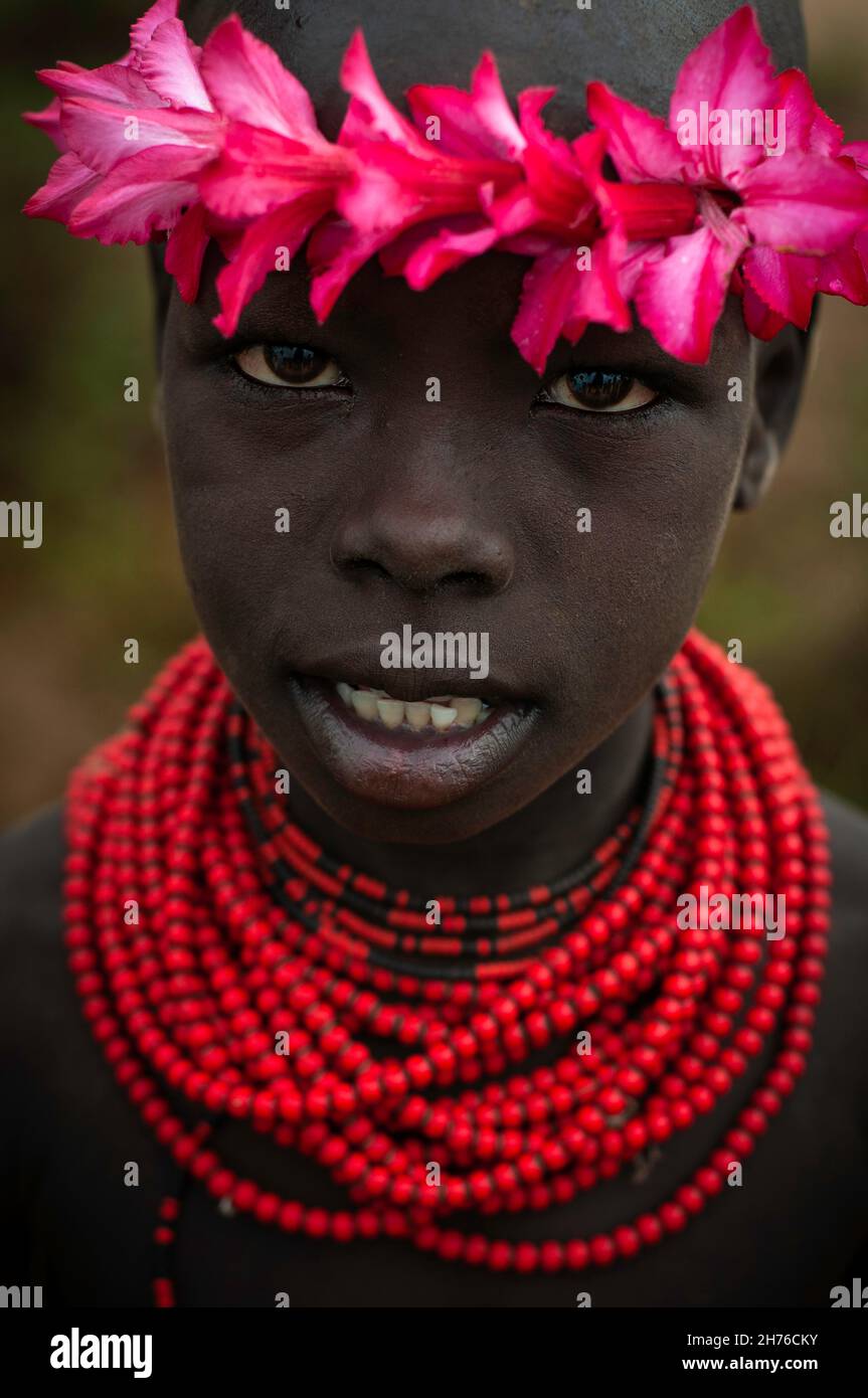 Niño de la tribu Karo con cuentas y flores Foto de stock