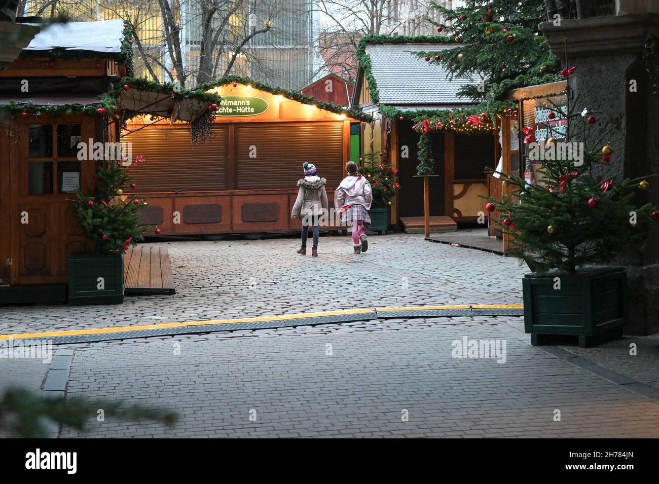 Lubeck, Alemania, 19 de noviembre de 2021: Dos niños de atrás caminando por el mercado cerrado de Navidad, esperando que se abra a pesar del pand del coronavirus Foto de stock