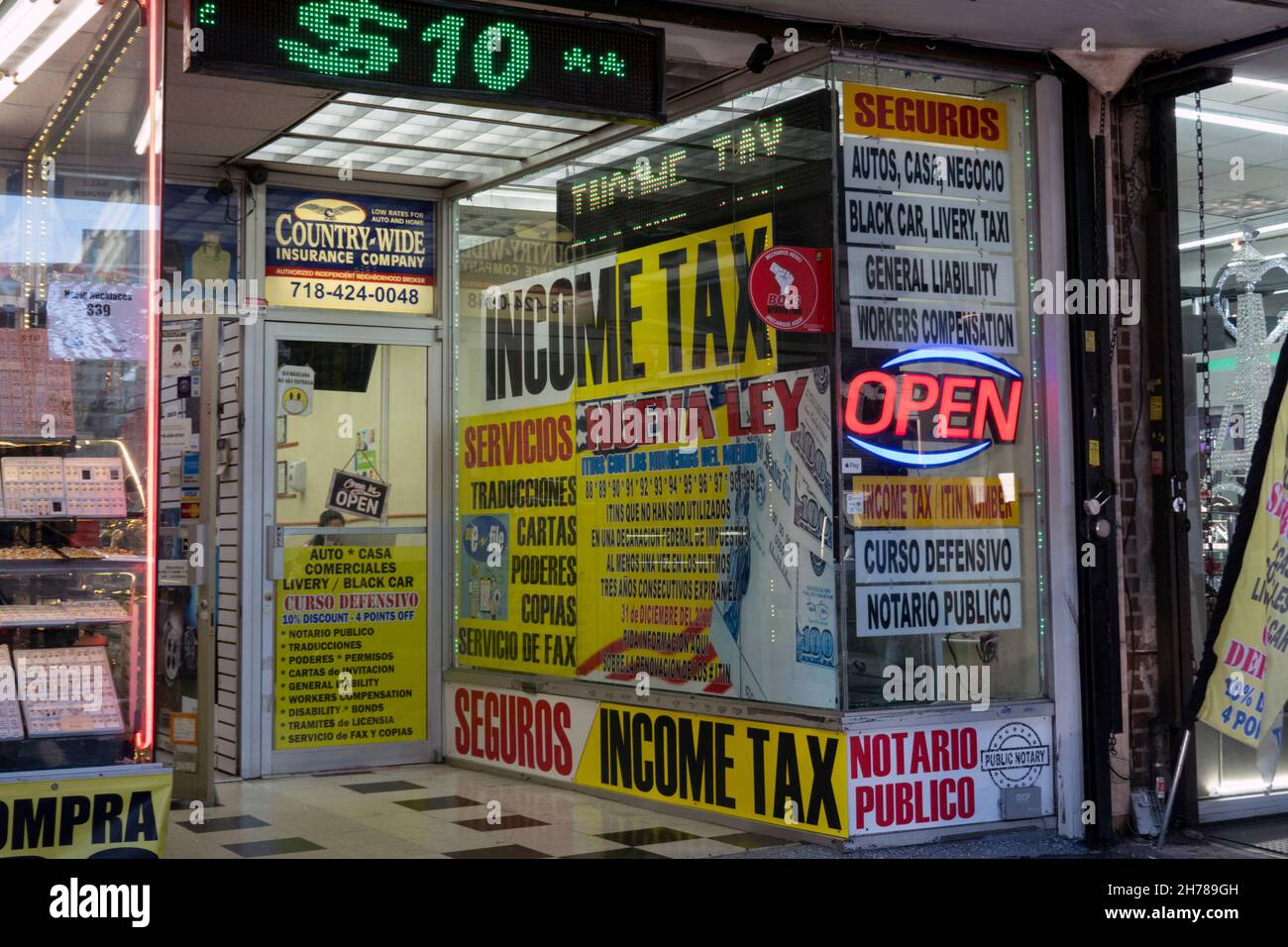 El español firma en un escaparate en Queens que prepara impuestos, da cursos de conductor y varios otros servicios financieros. Jackson Heights, Nueva York Foto de stock