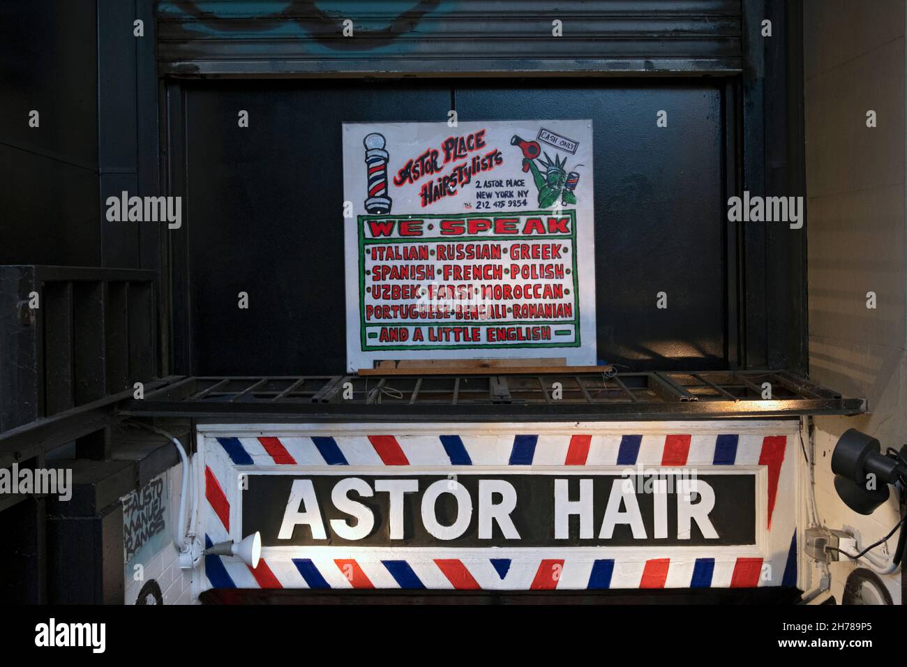 Un signo del camino abajo a los estilistas de Astor Hair en el East Village, Manhattan, Nueva York. Afirman que allí se hablan 13 idiomas. Foto de stock