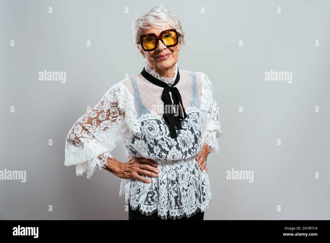 hermosa y elegante vieja mujer influyente. Abuela fresca posando en el  estudio con ropa de moda. Feliz señora mayor celebrando y haciendo pa  Fotografía de stock - Alamy