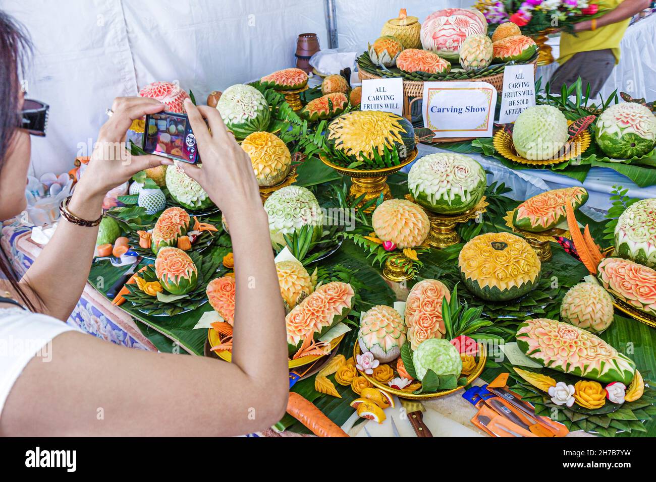 Miami Florida,Homestead,Redlands,Fruit & Spice Park,Festival de la Cultura Asiática,esculturas de frutas tailandesas arte culinario mujer cámara mujer tomando foto Foto de stock