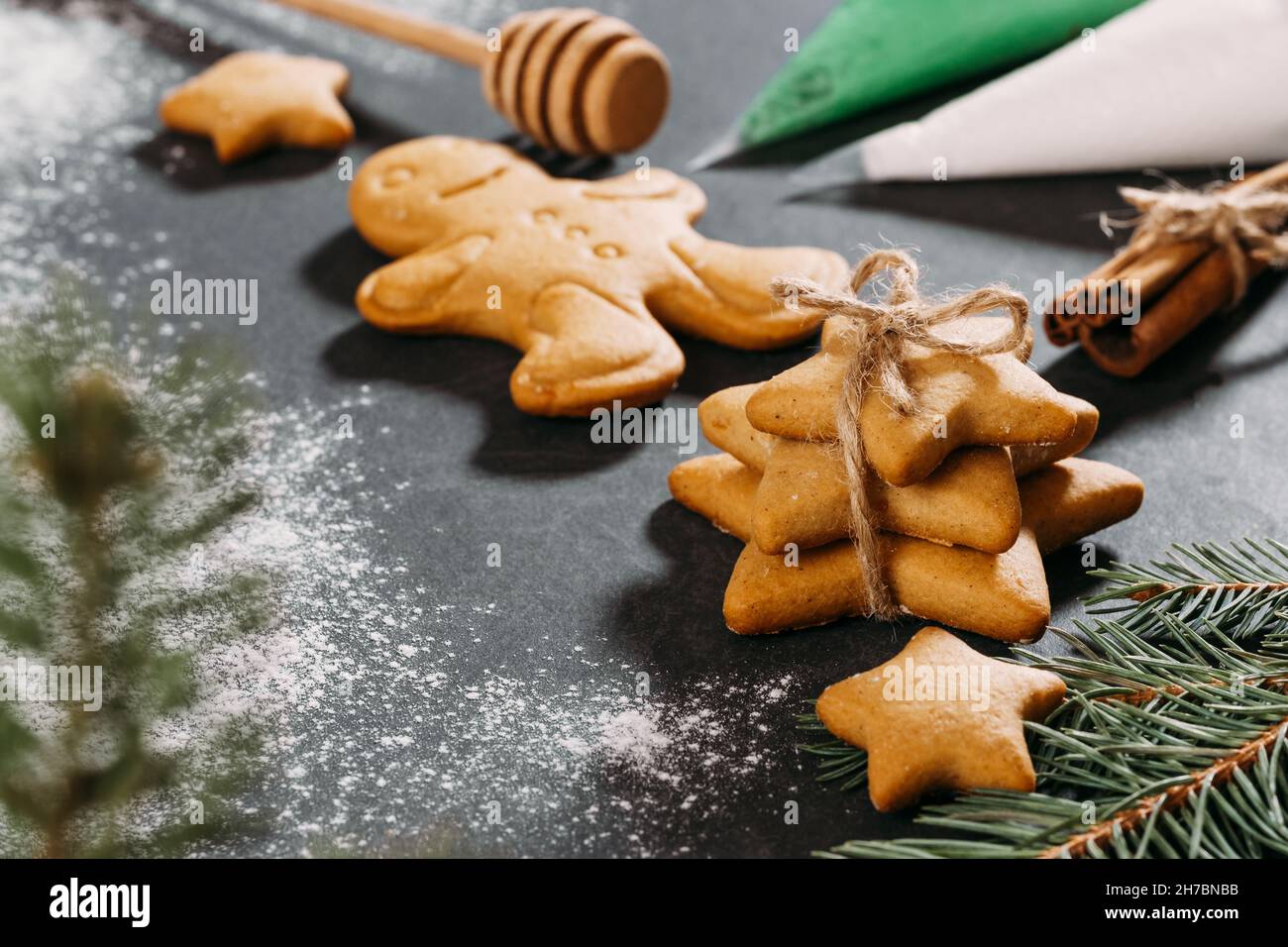 Galletas de pan de jengibre de Navidad listas para decorar con hielo, clavo aromático, jengibre, canela y rico árbol negro. Primer plano de la mesa. Estrellas y. Foto de stock