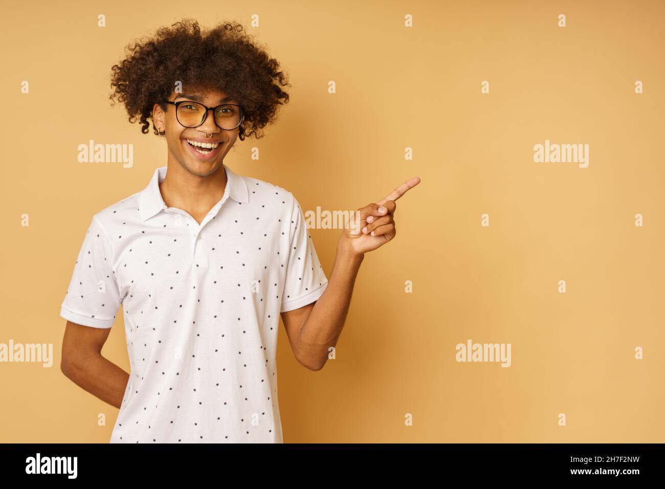 Un hombre feliz con gafas indica algo con la mano Foto de stock