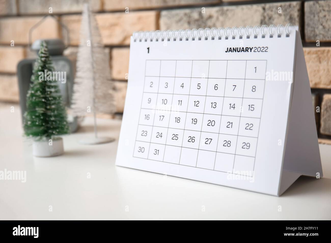 Calendario de papel para enero de 2022 en estante cerca de la pared de  ladrillo, primer plano Fotografía de stock - Alamy