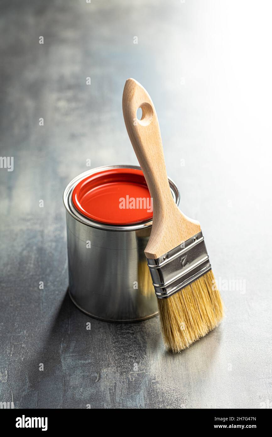 Limpie los cepillos de pintura y la lata de color de la mesa vieja. Foto de stock