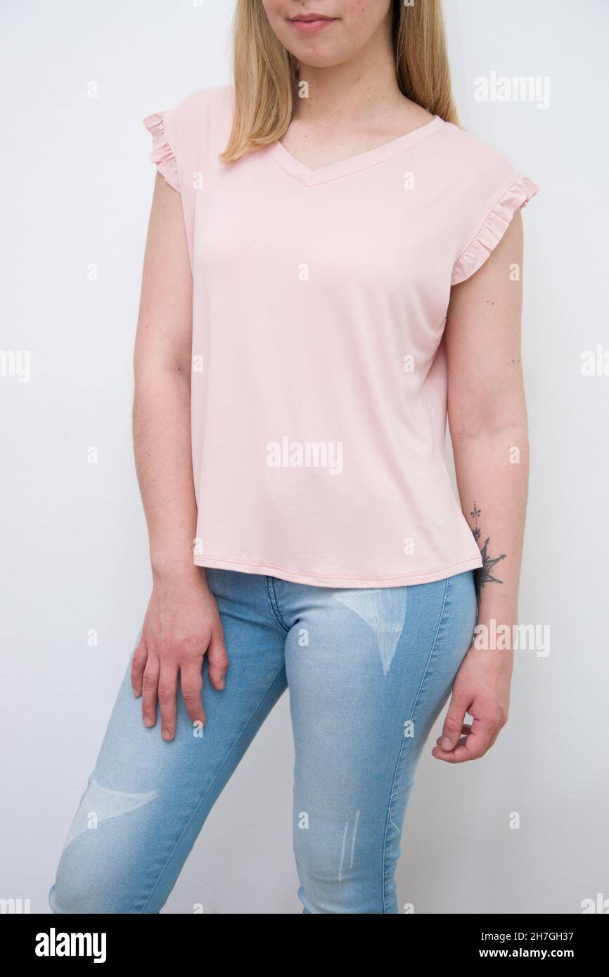 Mujer con una blusa rosa pastel combinada con un fondo de pared blanco Fotografía de - Alamy