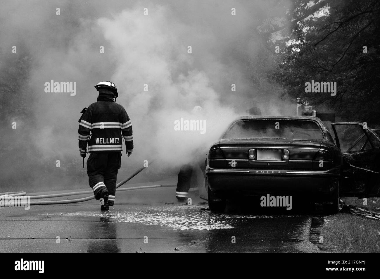 WHITEWATER, ESTADOS UNIDOS - 19 de octubre de 2021: Un disparo en escala de grises de un bombero en la escena de un incendio de un coche en Whitewater, Wisconsin, EE.UU Foto de stock