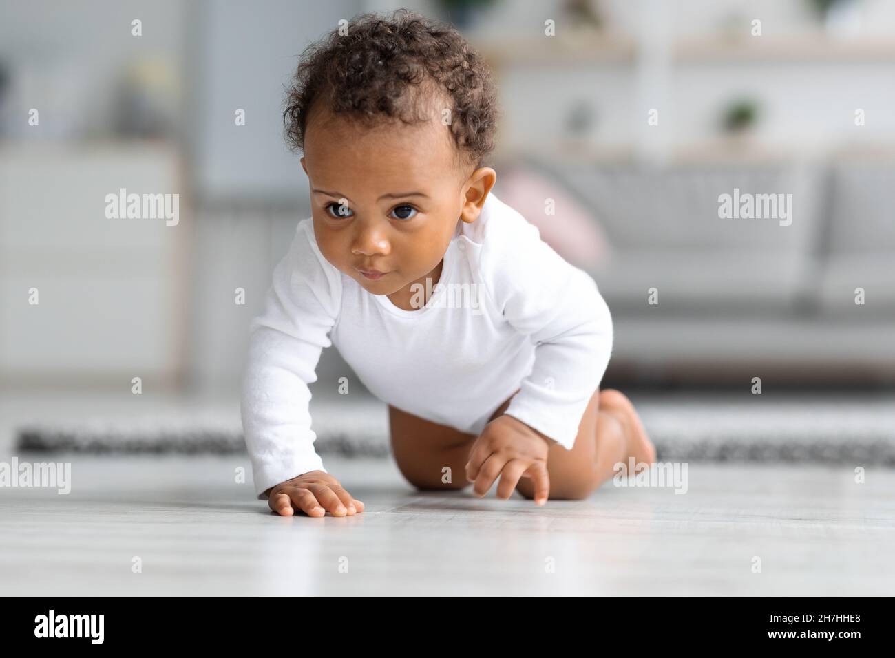 Bebé gateando por el suelo de una sala de estar