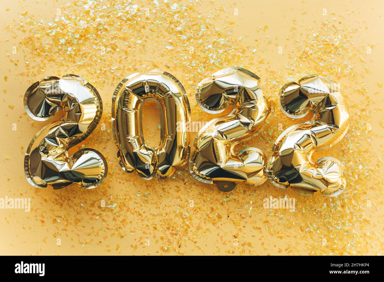 Globos hechos de papel de aluminio dorado con los números 2022 sobre fondo dorado. Celebración de Navidad, Año Nuevo y el concepto de vacaciones. Foto de stock