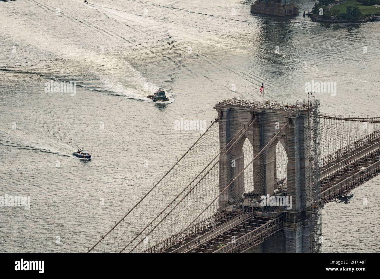 Remolcadores en el río East de Nueva York con el puente de Brooklyn, Nueva York, EE.UU. Foto de stock