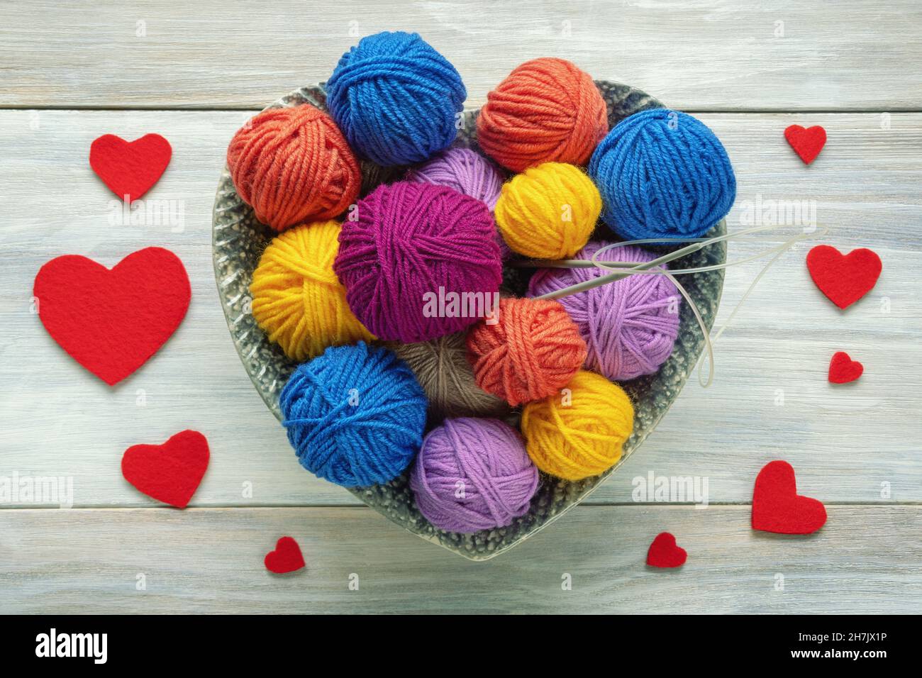 Tejido de lana en varios colores con ovillos y agujas foto de Stock