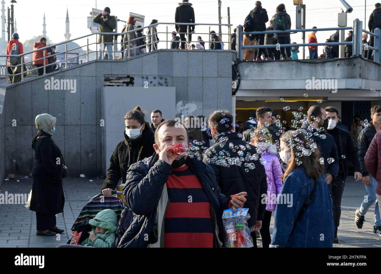 TURQUÍA, Estambul, estación de ferry de Eminönü, pandemia de corona, personas con máscaras faciales, vendedor de burbujas de jabón / Türkei, Estambul, Stadtteil Eminönü Fähranleger, Corona Pandemie, Passanten mit Masken Foto de stock