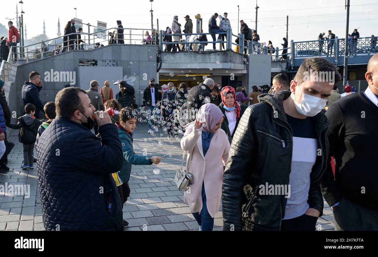 TURQUÍA, Estambul, estación de ferry de Eminönü, pandemia de corona, personas con máscaras faciales, vendedor de burbujas de jabón / Türkei, Estambul, Stadtteil Eminönü Fähranleger, Corona Pandemie, Passanten mit Masken Foto de stock