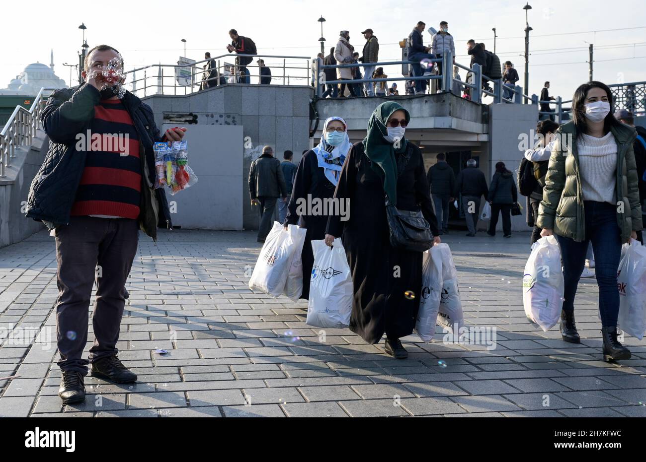 TURQUÍA, Estambul, estación de ferry de Eminönü, pandemia de corona, personas con máscaras faciales, vendedor de burbujas de jabón / Türkei, Estambul, Stadtteil Eminönü Fähranleger, Corona Pandemie, Passanten mit Masken Foto de stock