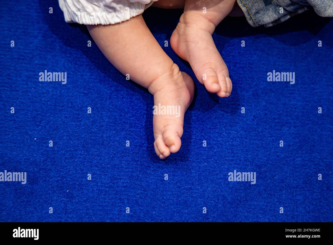 pie de 0 años sobre una alfombra azul Foto de stock