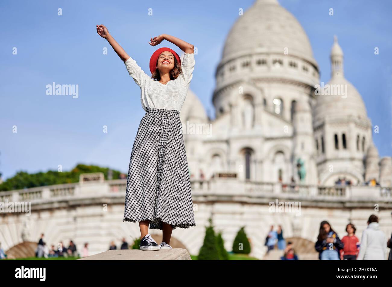 Mujer turística con las manos criadas en Basilique Du Sacre Coeur, Montmartre en París, Francia Foto de stock