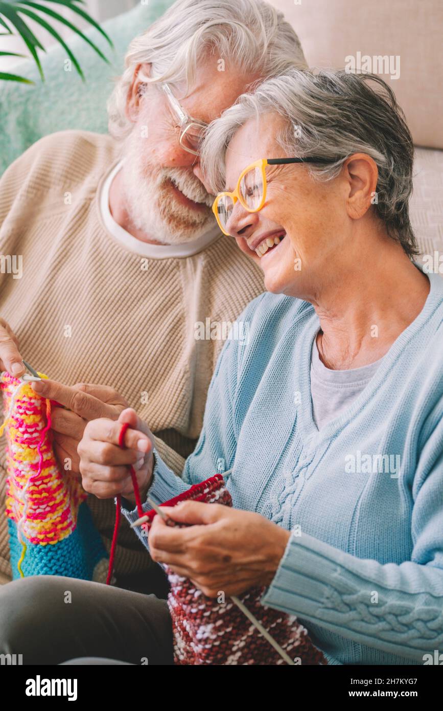 Feliz pareja mayor con aguja de punto en la sala de estar Foto de stock