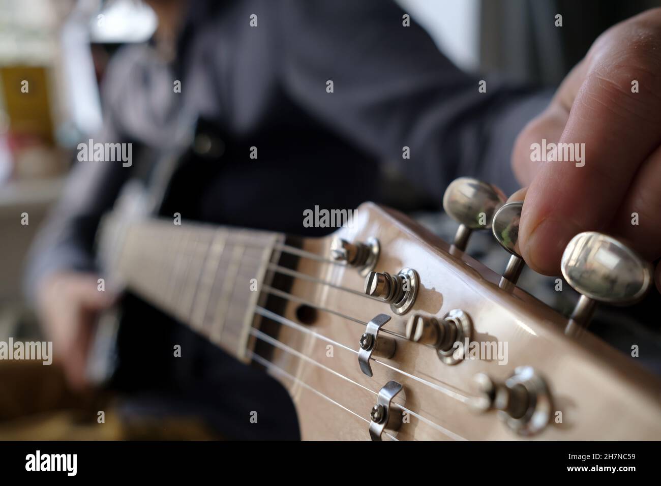 Las manos sintonizan la guitarra. Reparación de instrumentos musicales  Fotografía de stock - Alamy