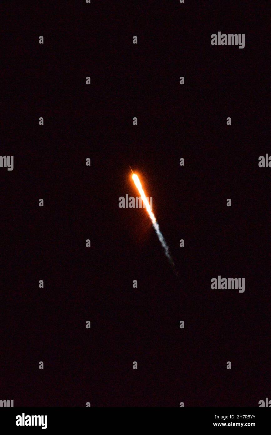 Un cohete Falcon 9 sube a la órbita por la noche. Foto de stock