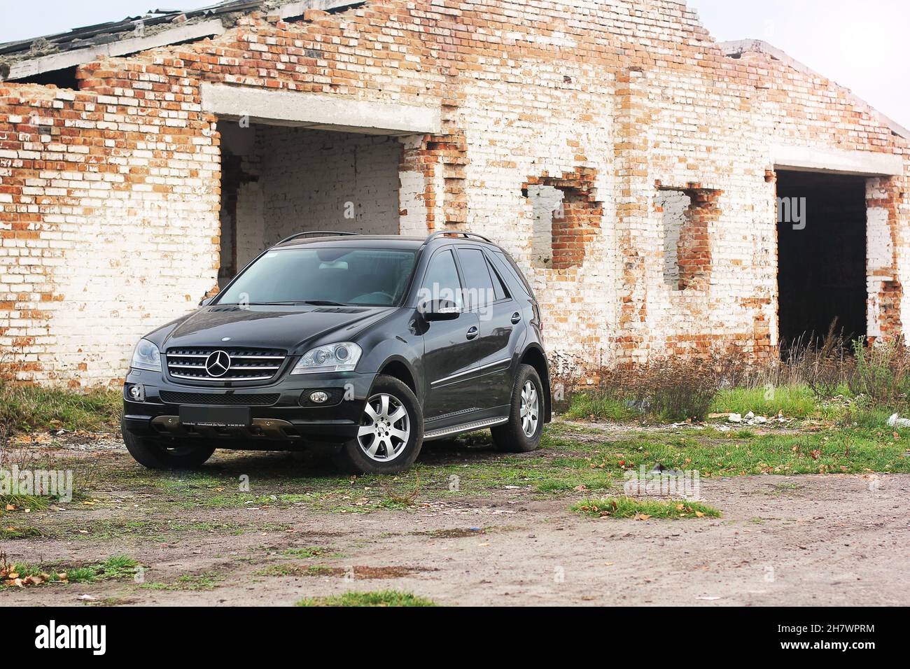 Popelnya, Ucrania - 10 de abril de 2014. Mercedes-Benz ML-Class en el fondo de un edificio destruido Foto de stock