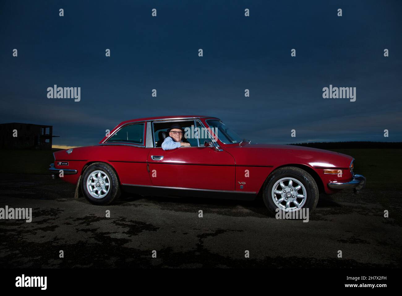 Un Triumph Stag V8 rojo con su orgulloso propietario Foto de stock