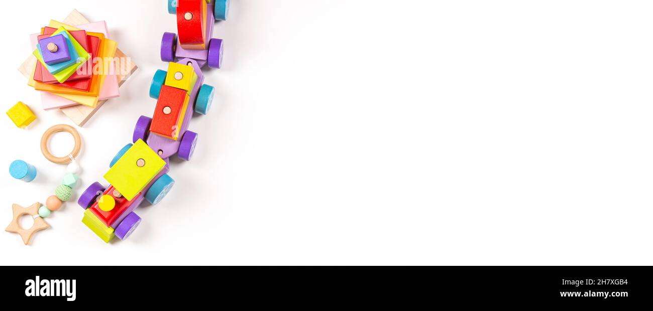 Bebé niños juguetes bandera fondo. Vista superior de coloridos juguetes educativos de madera sobre fondo blanco. Educación temprana, cero residuos, juguetes Montessori para Foto de stock