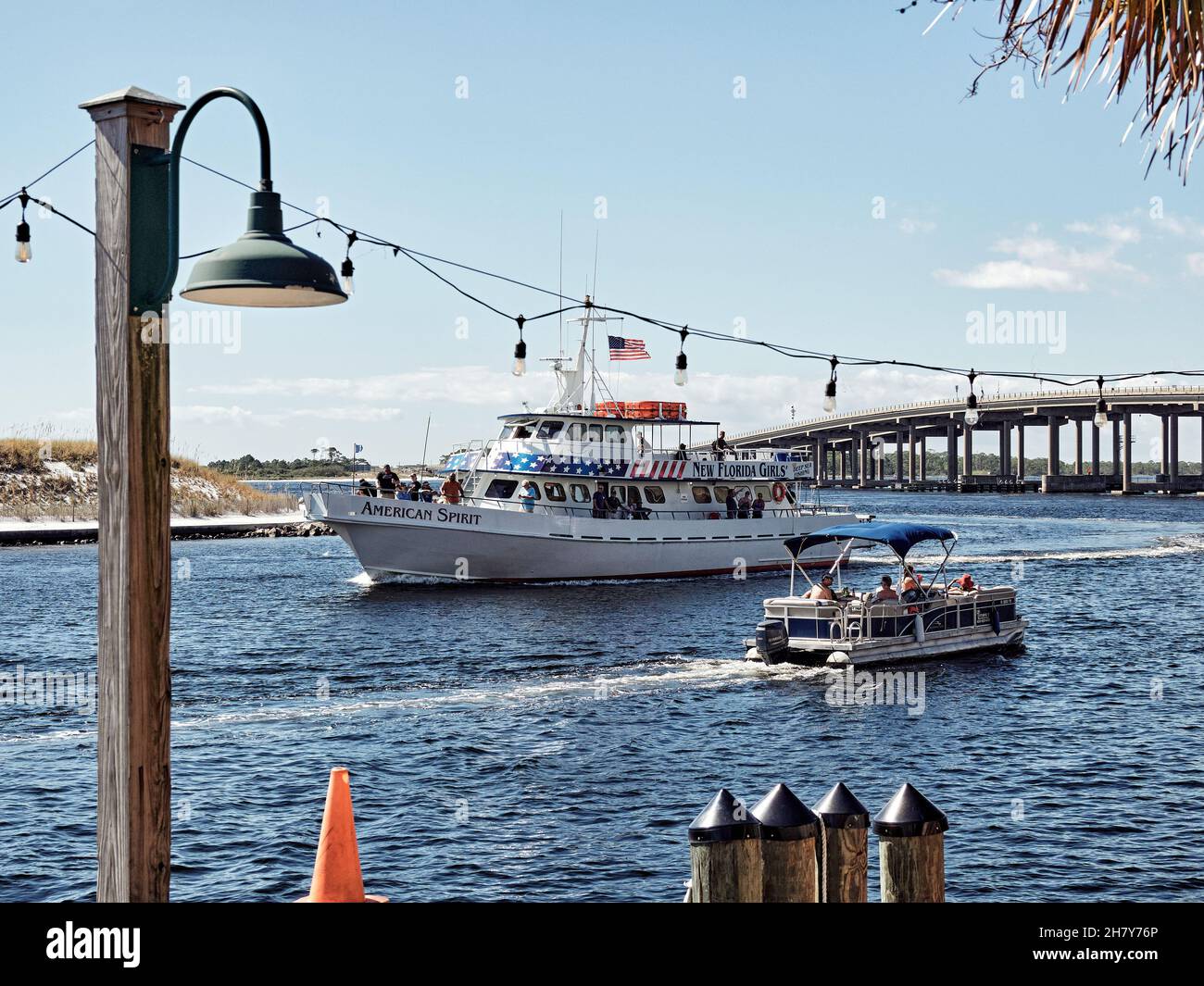 Gran barco de alquiler turístico pasando por un pequeño pontón familiar en East Pass, Destin Harbor, Destin Florida, Estados Unidos. Foto de stock