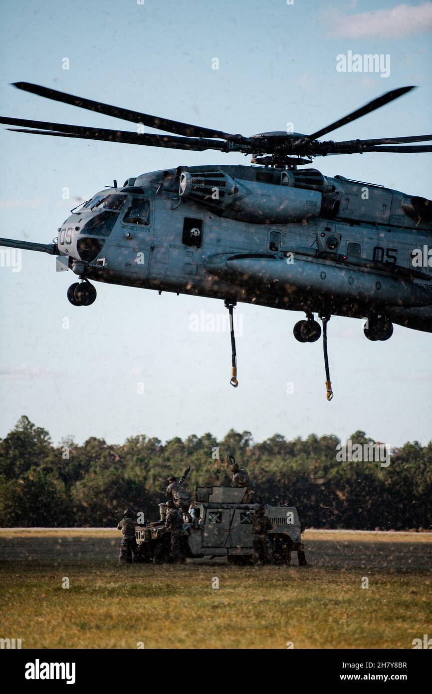 Los aviadores del Grupo de Defensa Base 820th, el Ala de Operaciones Aéreas Terrestres 93d y los soldados del Centro de Entrenamiento de Guerrero de la Guardia Nacional del Ejército se preparan para enganchar un Vehículo de Ruedas Multiusos de Alta Movilidad a un helicóptero “Super Stallion” del Cuerpo de Marina CH-53 en la Base de la Fuerza Aérea Moody, Georgia, 17 de noviembre de 2021. El Ala de Operaciones Aéreas en Tierra de 93d, el Escuadrón de Helicópteros Pesados Marinos 366 y el Centro de Entrenamiento de Guerrero de la Guardia Nacional del Ejército llevaron a cabo entrenamiento de carga de cabestrillos para practicar la recolección y entrega aérea eficiente. (EE.UU Foto de la Fuerza Aérea de 1st Lt. Katie Tamesis) Foto de stock