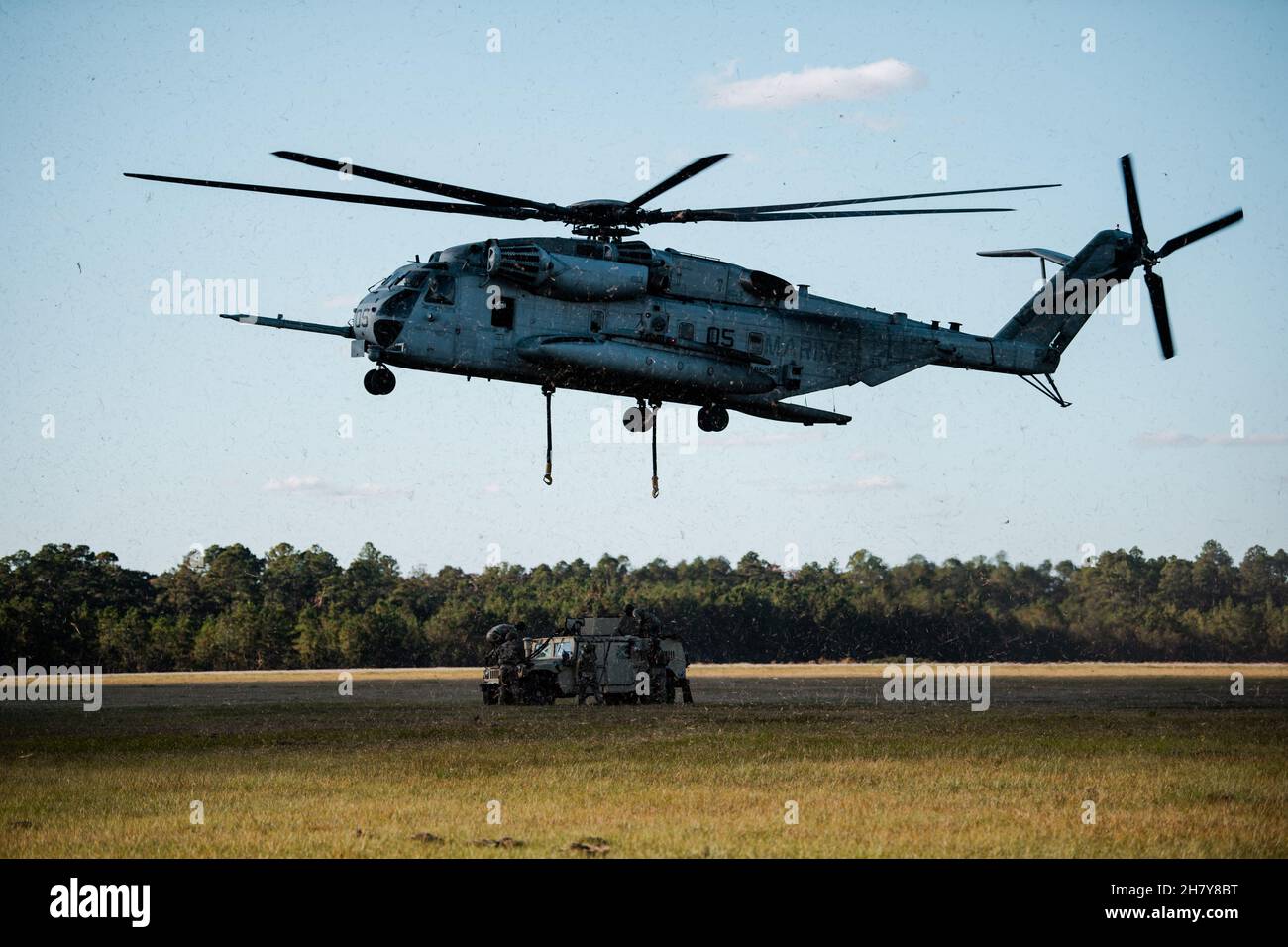 Los aviadores del Grupo de Defensa Base 820th, el Ala de Operaciones Aéreas Terrestres 93d y los soldados del Centro de Entrenamiento de Guerrero de la Guardia Nacional del Ejército se preparan para enganchar un Vehículo de Ruedas Multiusos de Alta Movilidad a un helicóptero “Super Stallion” del Cuerpo de Marina CH-53 en la Base de la Fuerza Aérea Moody, Georgia, 17 de noviembre de 2021. El Ala de Operaciones Aéreas en Tierra de 93d, el Escuadrón de Helicópteros Pesados Marinos 366 y el Centro de Entrenamiento de Guerrero de la Guardia Nacional del Ejército llevaron a cabo entrenamiento de carga de cabestrillos para practicar la recolección y entrega aérea eficiente. (EE.UU Foto de la Fuerza Aérea de 1st Lt. Katie Tamesis) Foto de stock
