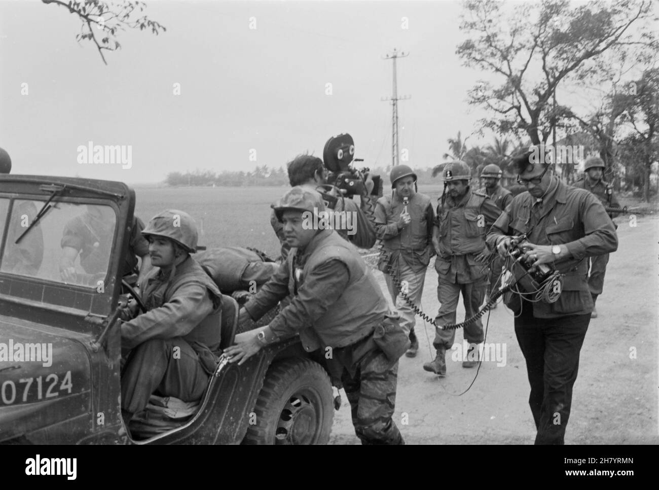 HUE, VIETNAM - 20 de febrero de 1968 - Walter Cronkite (micrófono de sujeción central derecho) y un equipo de cámaras CBS utilizan un jeep para una dolly durante una entrevista w Foto de stock