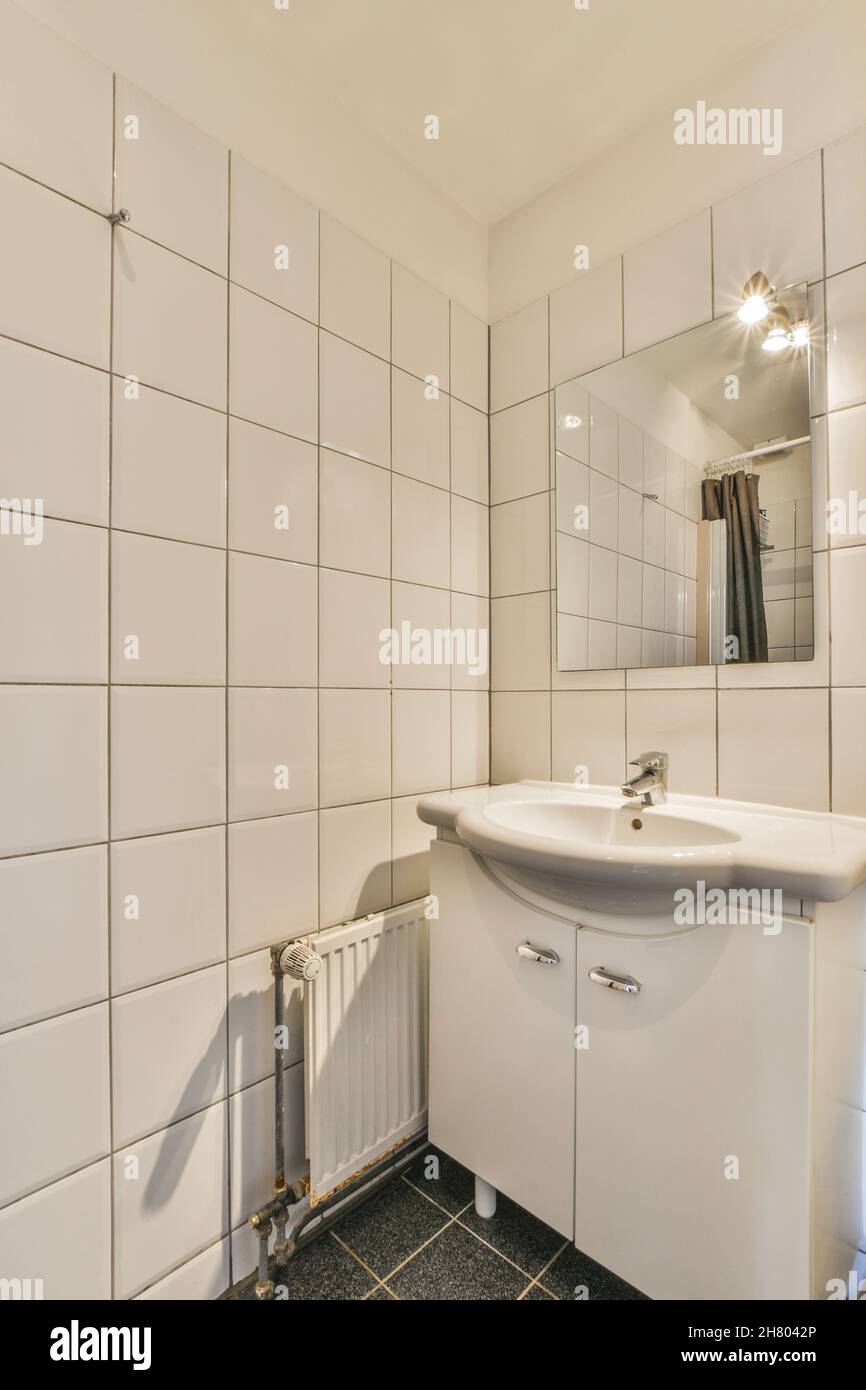 Lavabo de cerámica blanca en el baño con paredes de azulejos claros en el  apartamento Fotografía de stock - Alamy