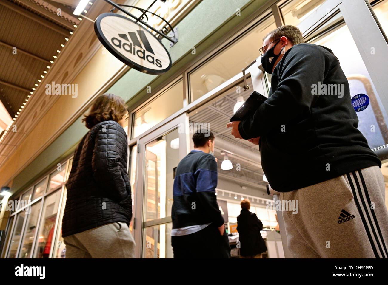 Un empleado saluda a los huéspedes en la puerta de una tienda Adidas, ya  que las ventas de Black Friday comienzan en Outlet Shoppes of the Bluegrass  en Simpsonville, Kentucky, EE.UU., 26