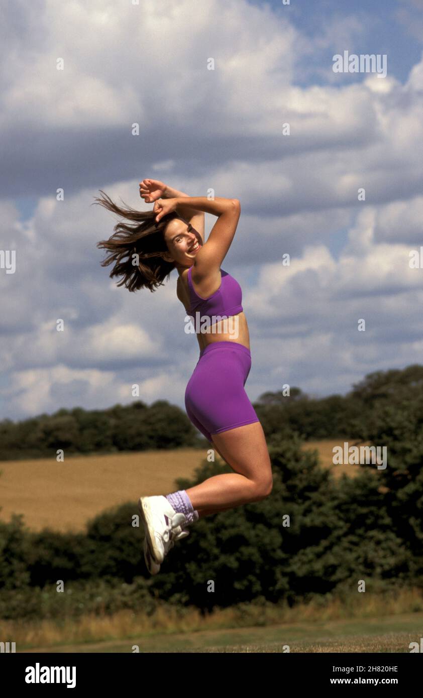 una adolescente sana en el campo saltando en el aire Foto de stock