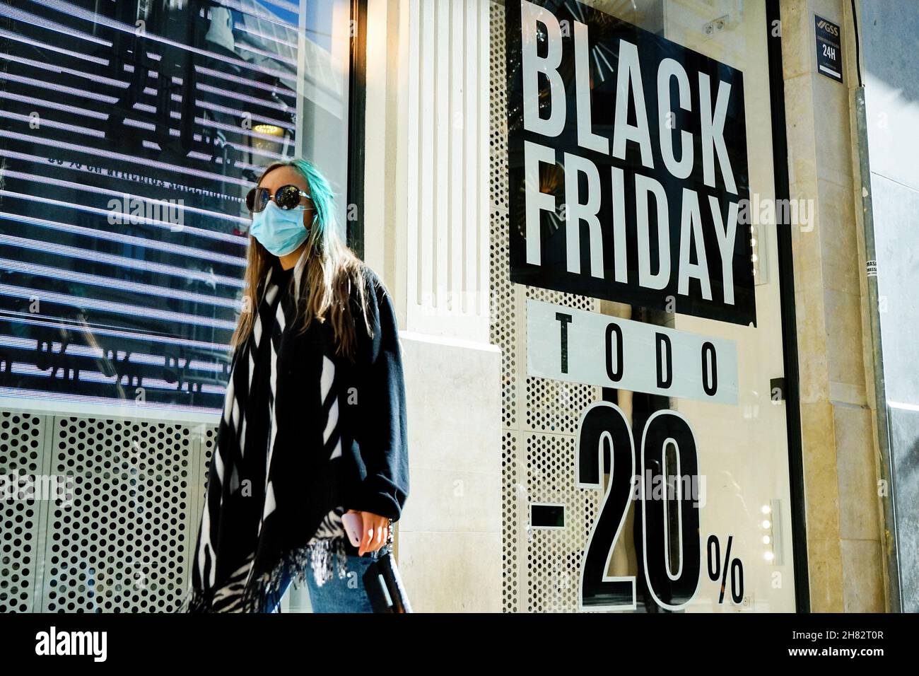 Málaga, España. 26th Nov, 2021. Una mujer pasa por delante de un cartel de  venta de Black Friday en un escaparate Bershka en Málaga.En 2021, el  comercio en línea ha crecido un