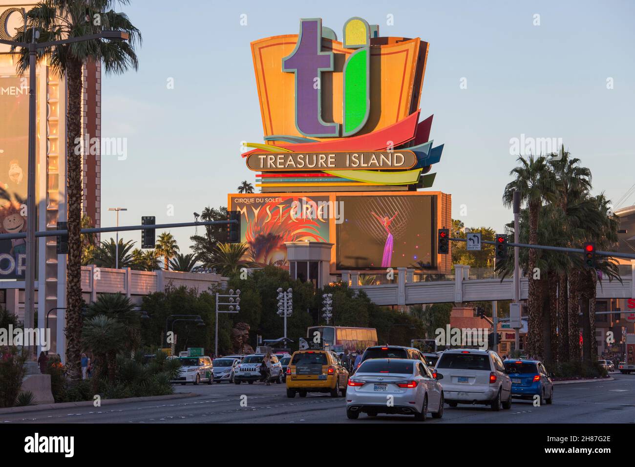 Las Vegas, Nevada, Estados Unidos. Vea a través del Strip a la colorida señal de neón que promociona el Treasure Island Hotel and Casino, puesta de sol. Foto de stock