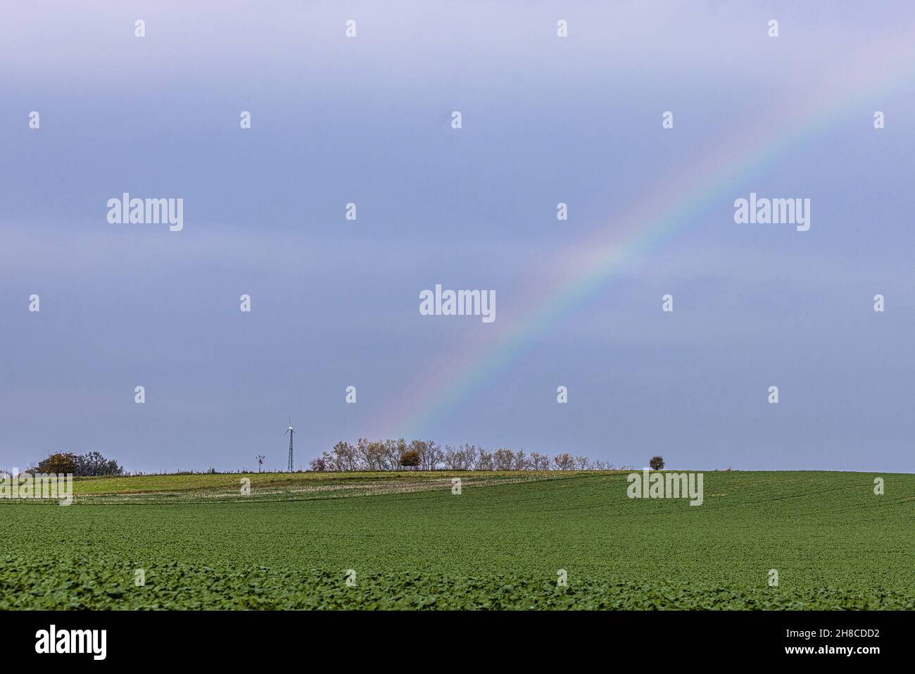 Pequeña rueda de viento en paisaje de campo con arco iris, Alemania, Baviera Foto de stock