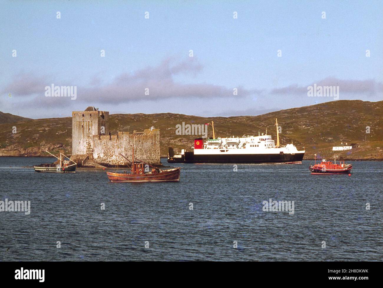 El MV Iona en castlebay con el castillo Kisimul en vista, Isla de Barra 1970s Foto de stock