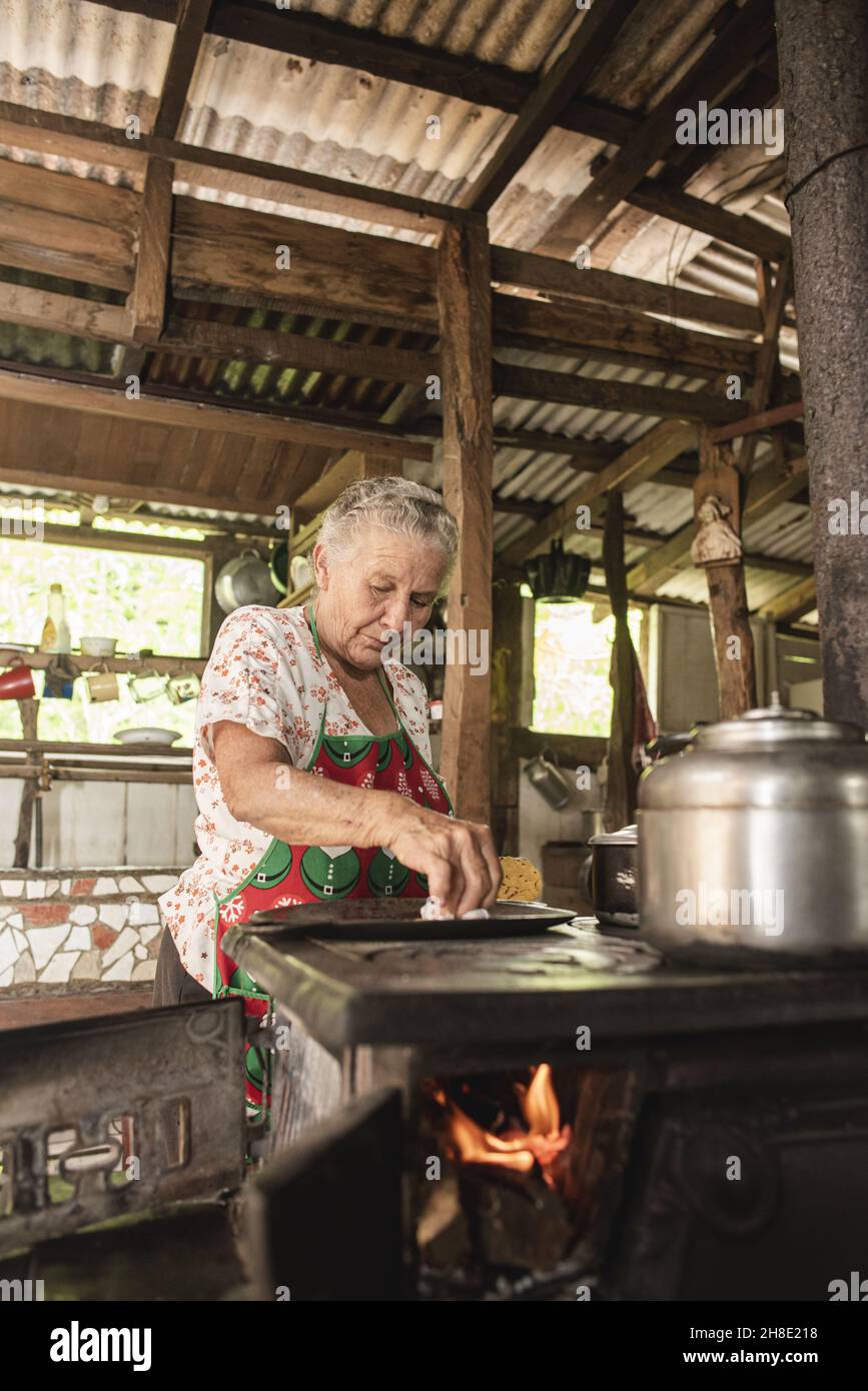 comal metálico muy caliente cocinando unas tortillas de maíz típicas de  guanacaste costa rica, en una estufa de acero a la leña foto de Stock