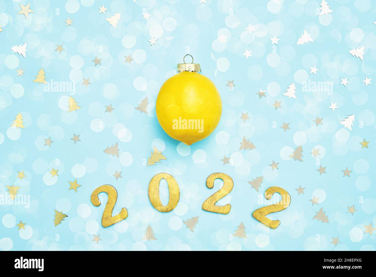 Tarjeta de felicitación de Año Nuevo 2022 con limón y dorado en fondo azul. Vista superior Foto de stock